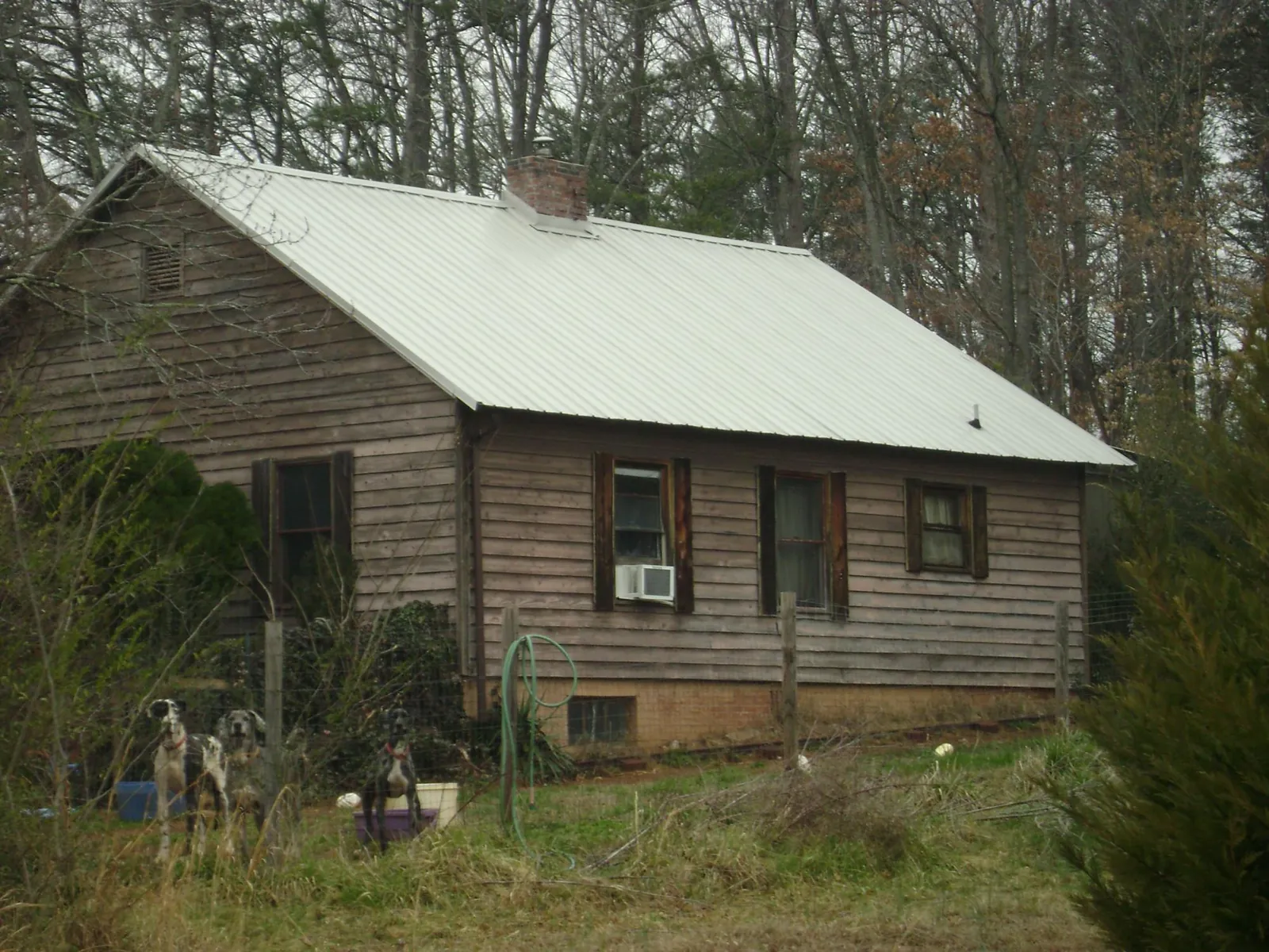 White metal roof on an old wood sided farmhouse, from a Metal Roof Installation job in Highland